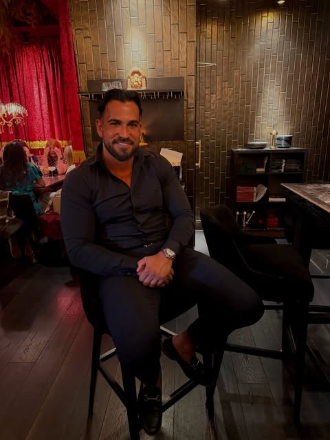 Addam Sattar seated in a dark shirt at an evening venue